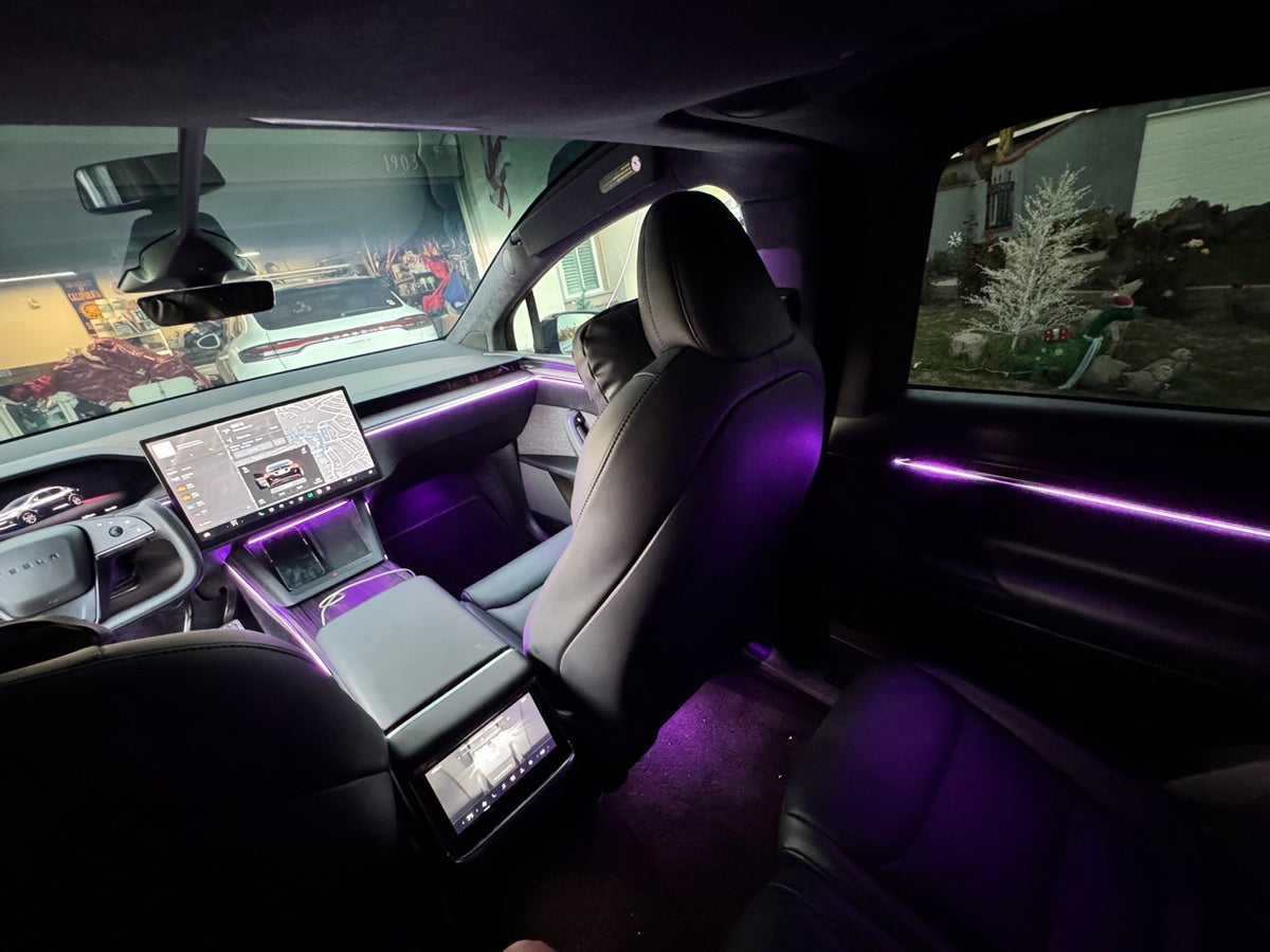 Tesla Model X rear cabin at night with purple ambient lighting