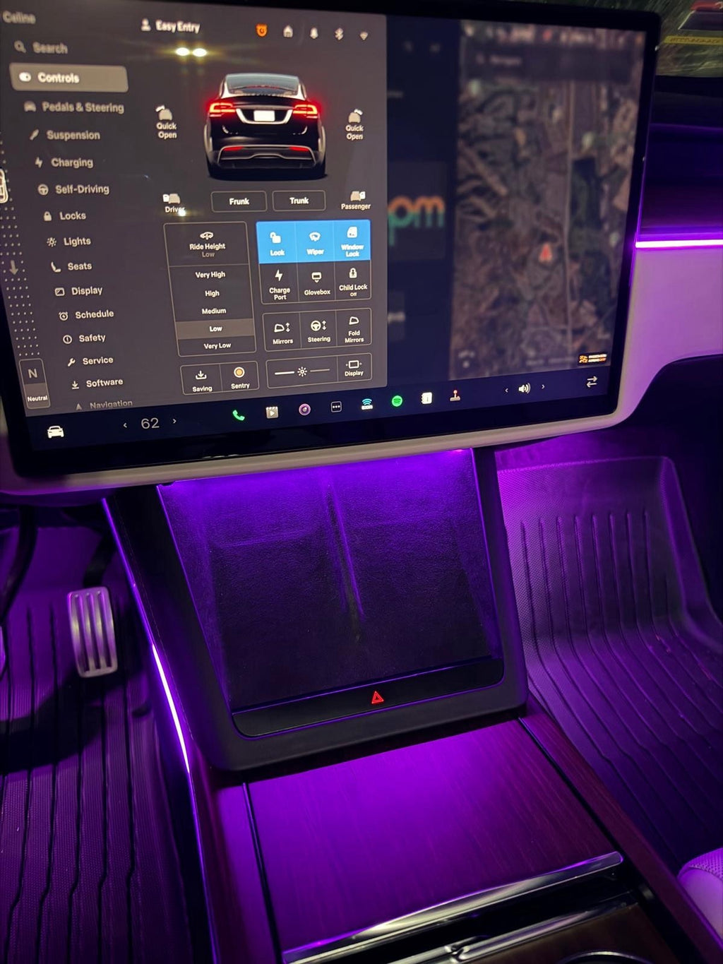 Tesla Model X center screen and console with purple ambient lighting