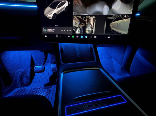 Tesla Model Y cabin with blue TslaModz ambient lighting — center console and footwells
